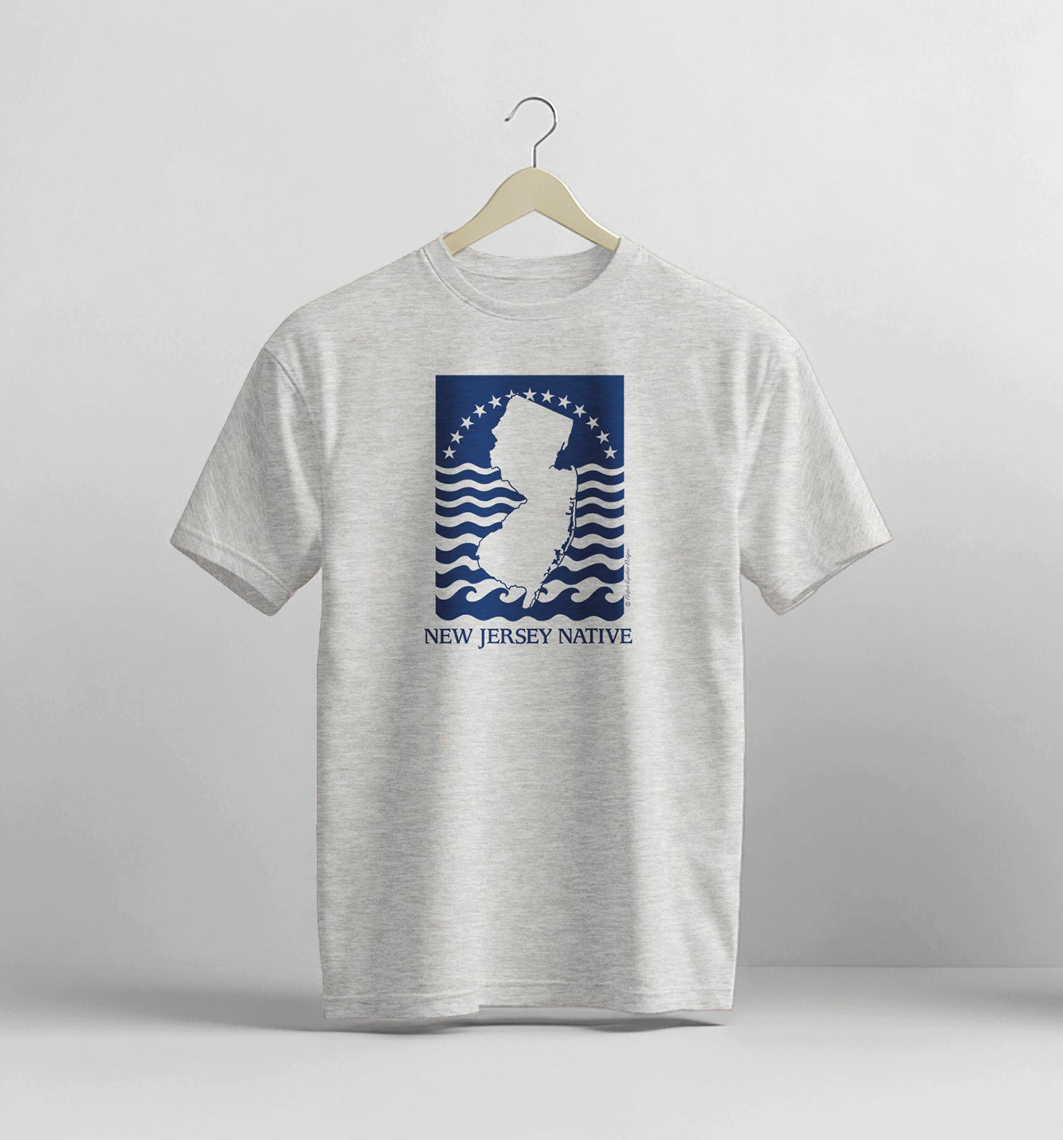 Gray t-shirt with New Jersey Native graphic on a hanger against a light gray background