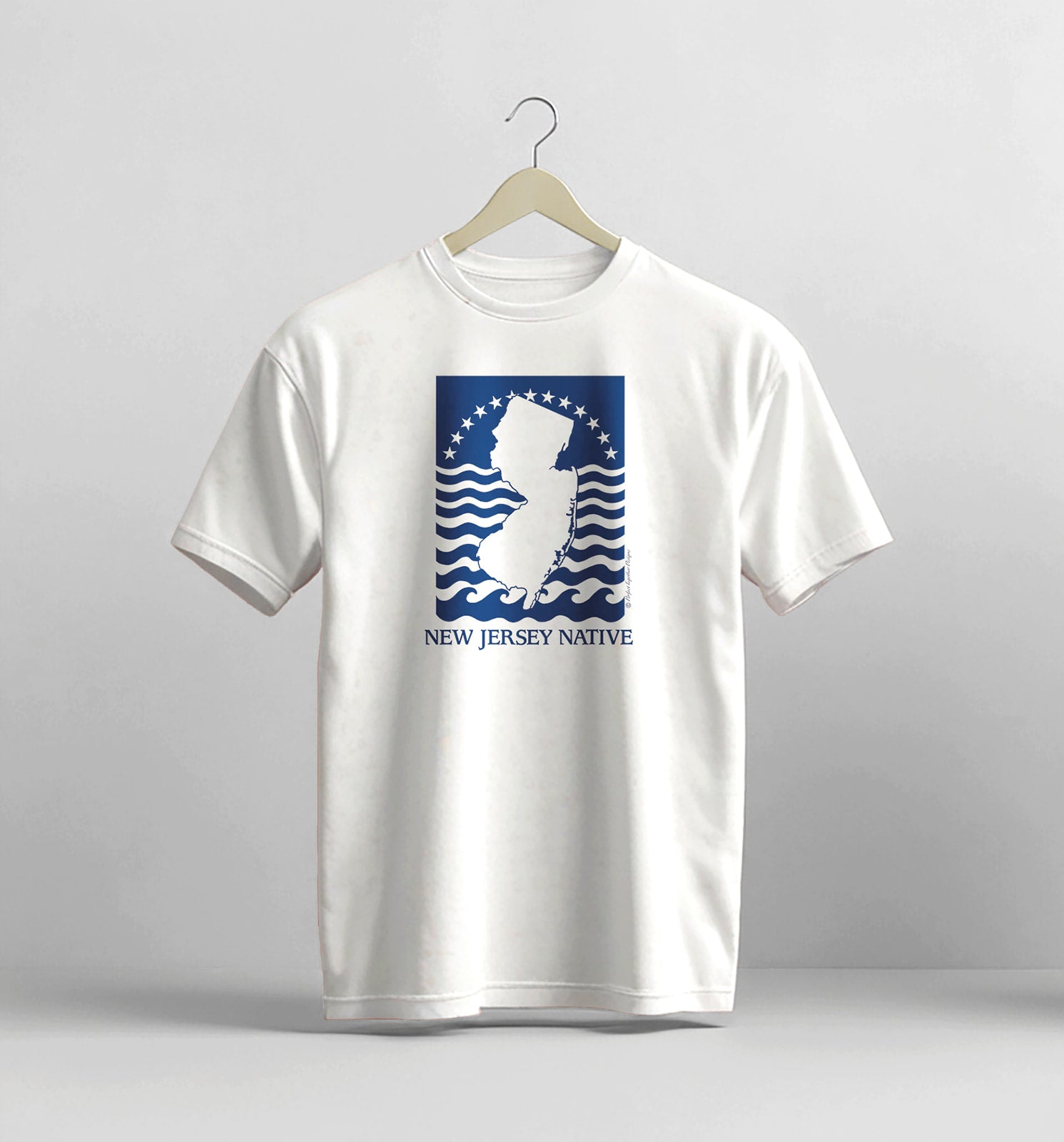 White t-shirt with New Jersey Native graphic on a hanger against a gray background