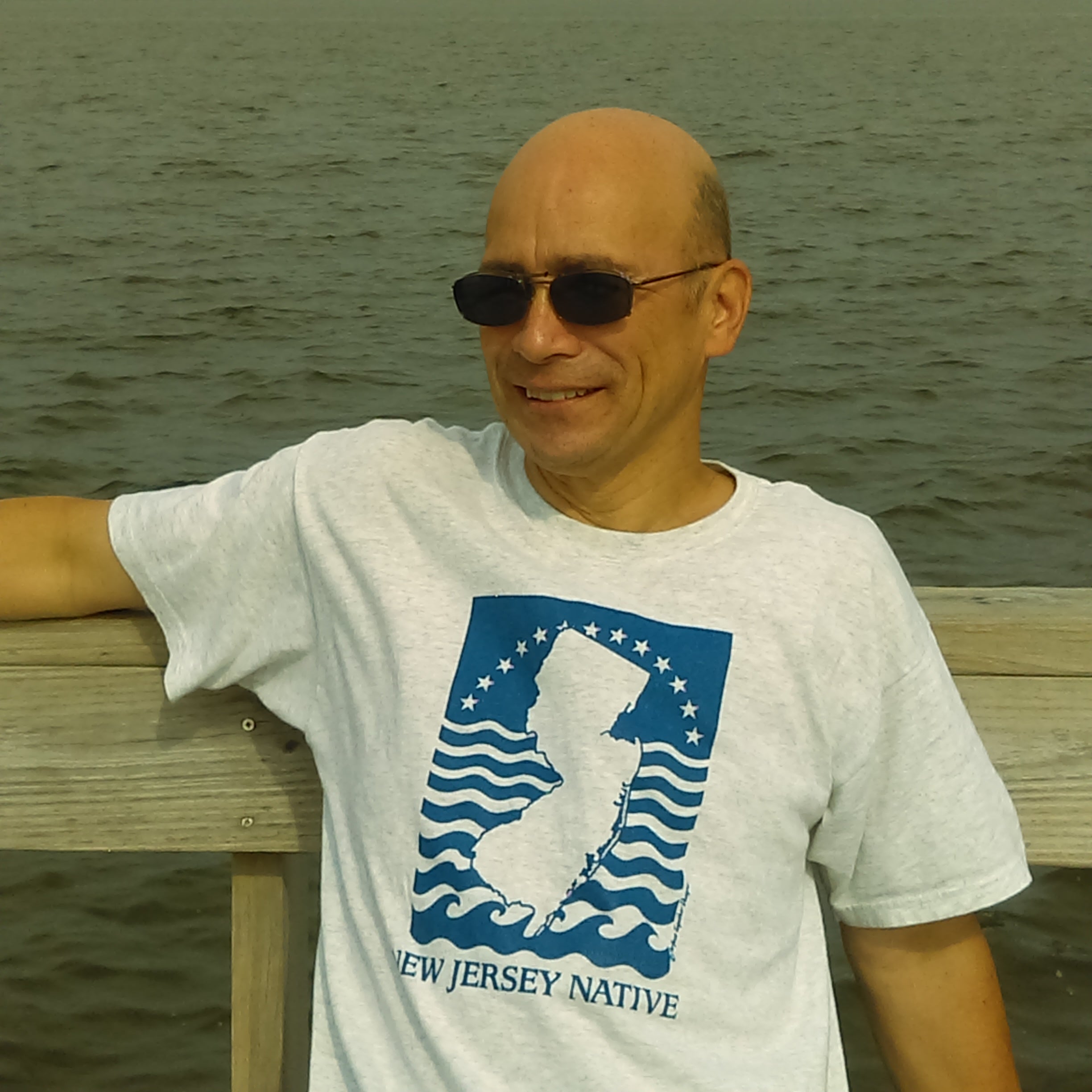 Man wearing a 'New Jersey Native' t-shirt by the water