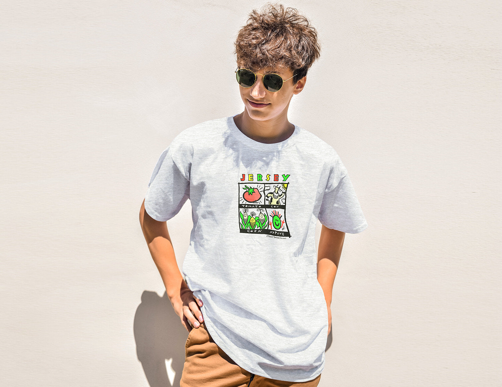 Person wearing a white t-shirt with a colorful graphic design on a plain background