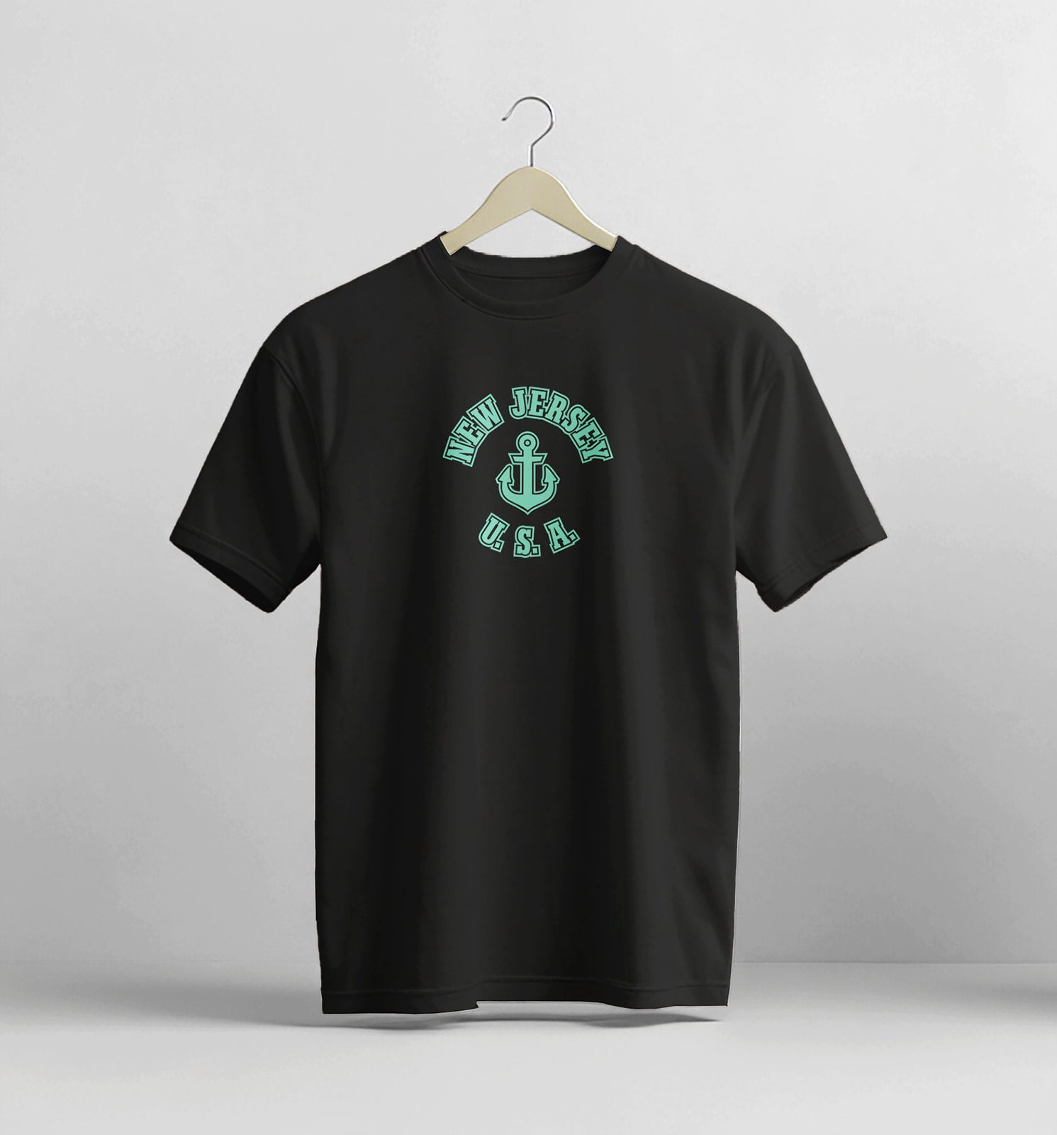 Black t-shirt with 'New Jersey USA' design on a hanger against a light gray background