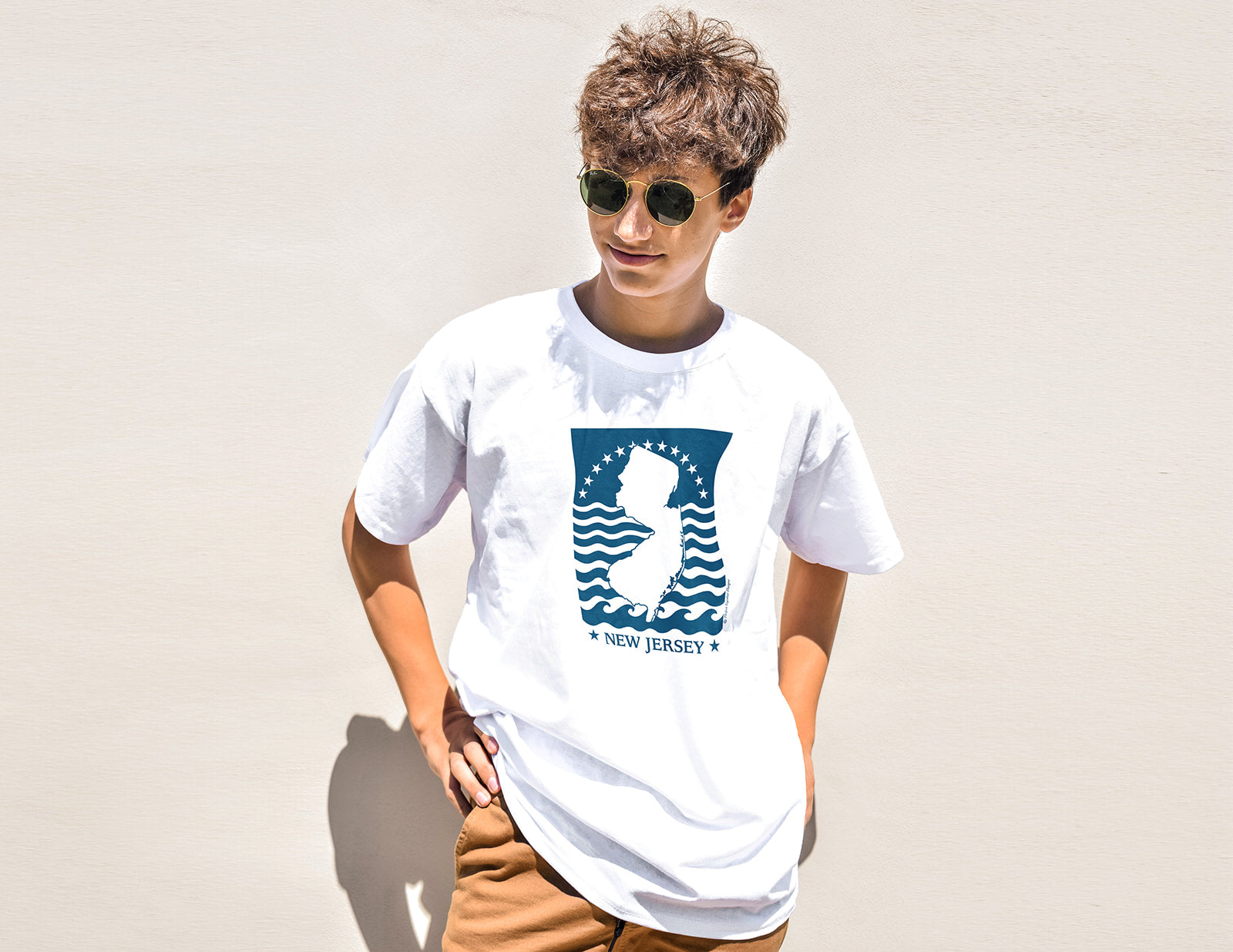 Person wearing a white t-shirt with a graphic design on a plain background