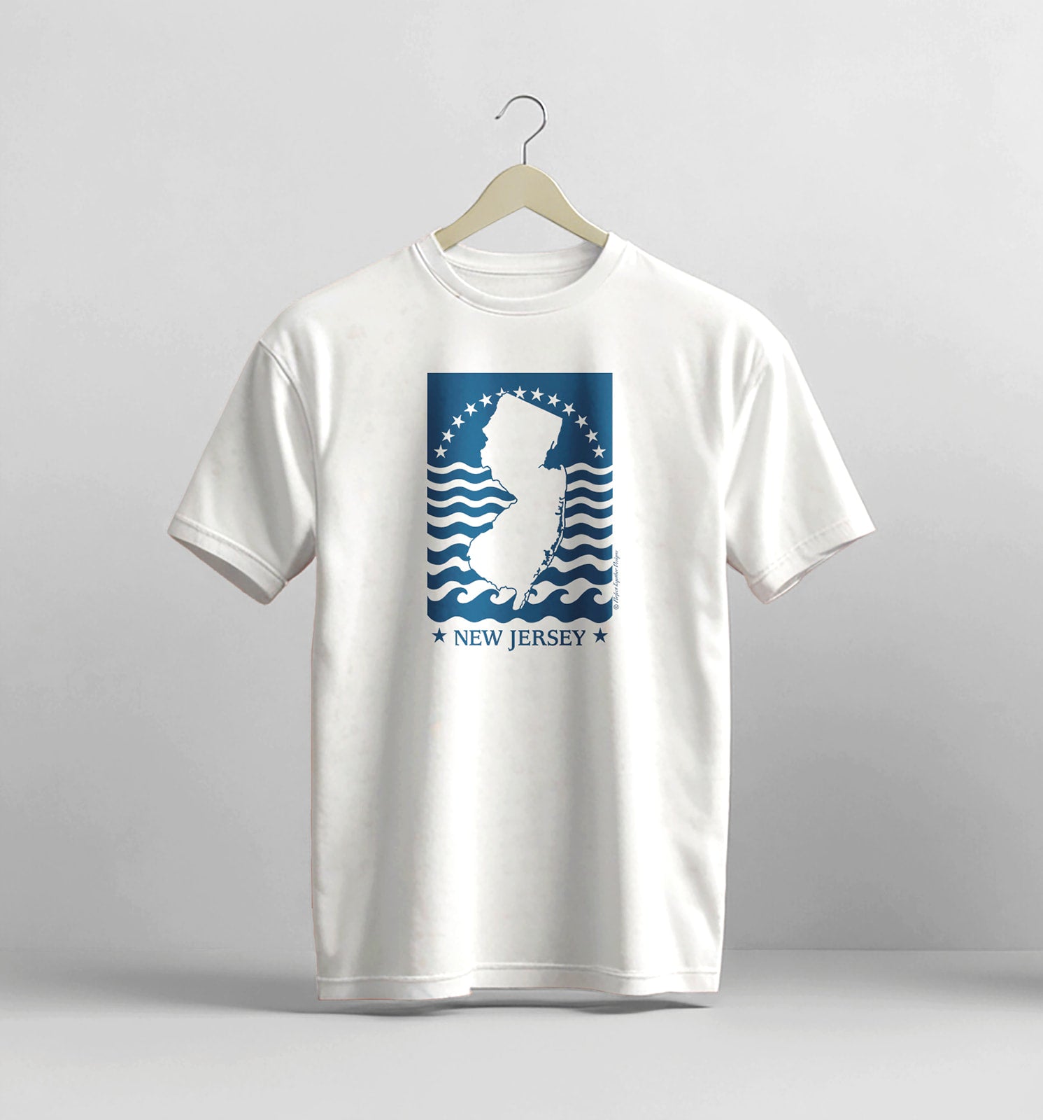White t-shirt with New Jersey graphic on a hanger against a gray background