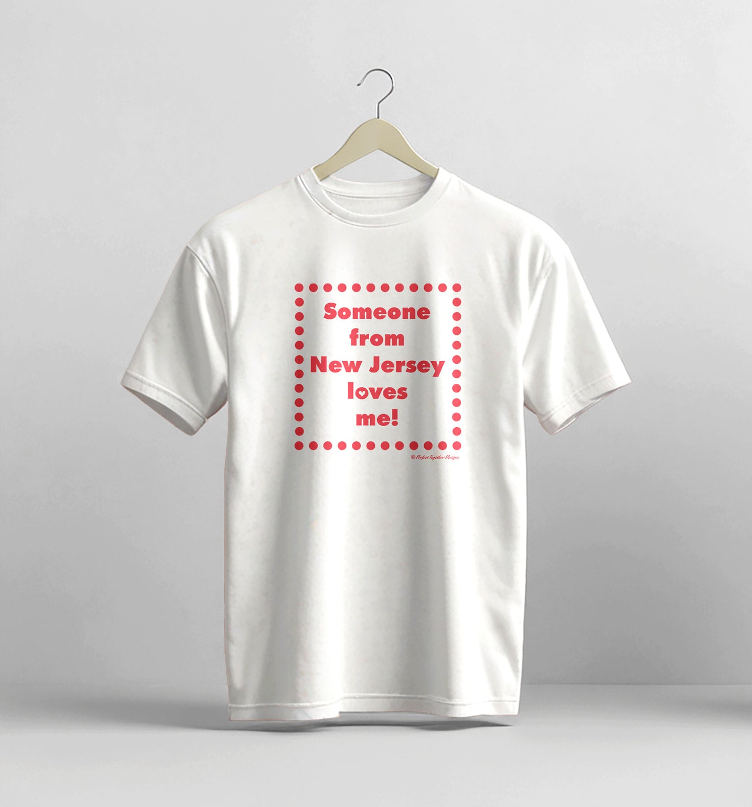 White t-shirt with red text on a hanger against a gray background