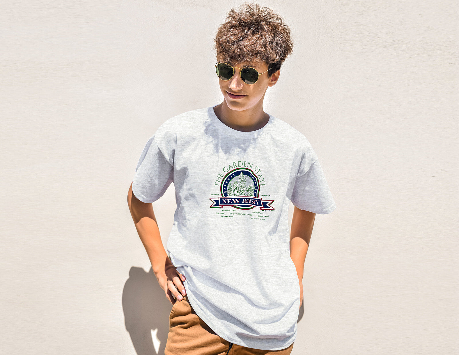 Person wearing a white t-shirt with a colorful graphic design on a plain background
