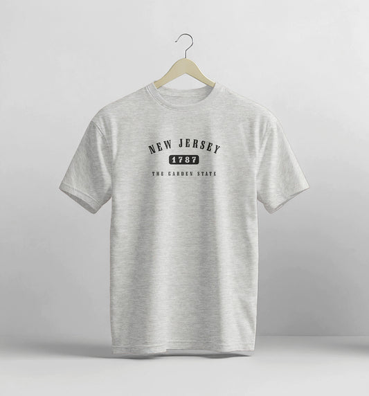 Gray t-shirt with 'New Jersey 1787' text on a hanger against a light gray background