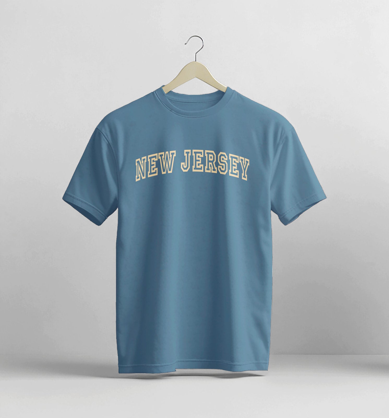 Blue t-shirt with 'New Jersey' text on a hanger against a gray background