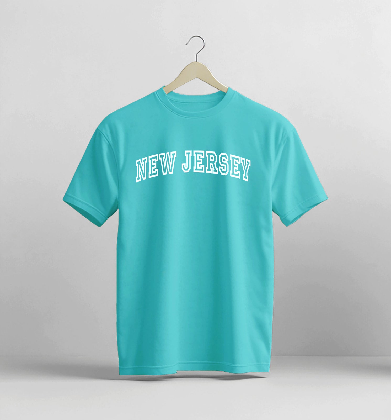 Turquoise t-shirt with 'New Jersey' text on a hanger against a gray background