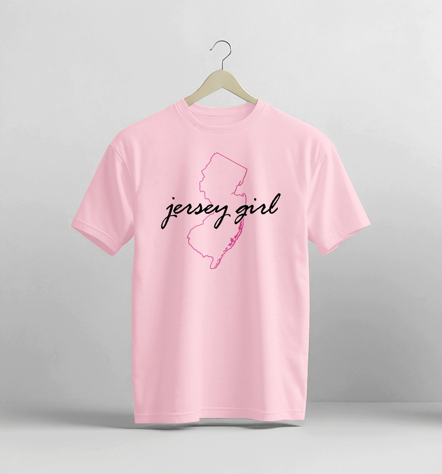 Pink t-shirt with 'jersey girl' text and New Jersey outline on a gray background