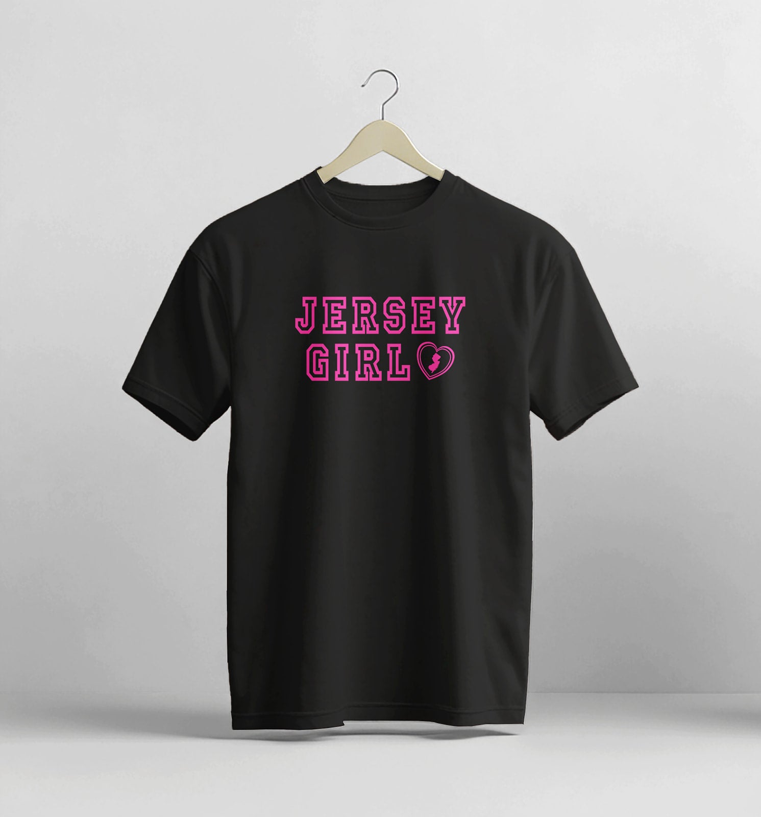 Black t-shirt with 'Jersey Girl' text on a hanger against a gray background